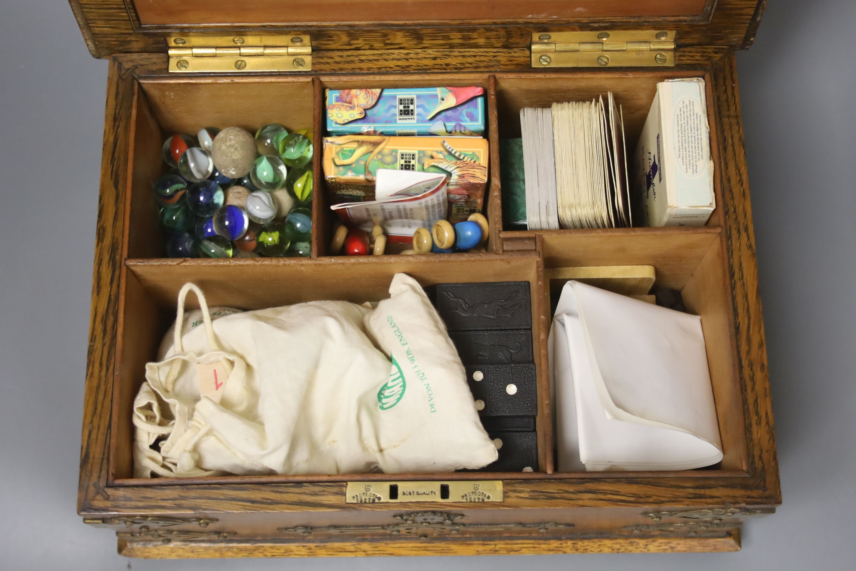 An oak games compendium with plated mounts and contents, 14 x 30cm